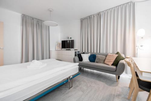 um quarto de hotel com uma cama e um sofá em Warta River Comfort Apartment em Poznań