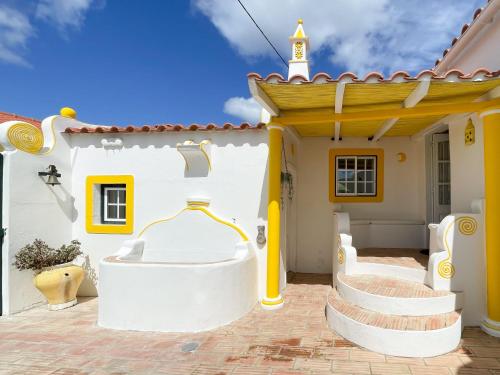 a home with a yellow and white house at Charming Countryside Home with Fireplace & Patio in Alcoutim
