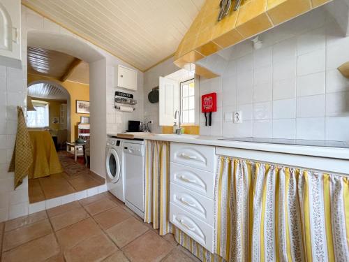 a kitchen with a washer and dryer at Charming Countryside Home with Fireplace & Patio in Alcoutim