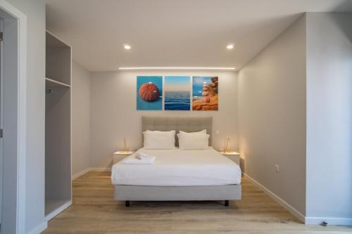 una camera con un letto bianco e due lampade di Ouri in Blue House a Jardim do Mar