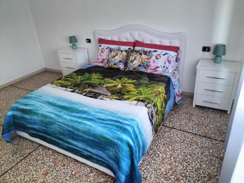 1 dormitorio con 1 cama con colcha tropical en Serravalle Apartment 2, en Serravalle Scrivia