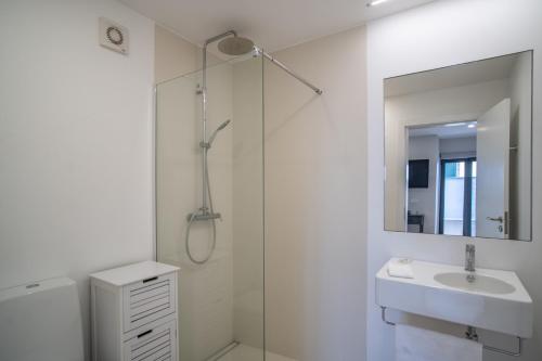 Ouri in Blue House في جارديم دو مار: حمام أبيض مع حوض ودش