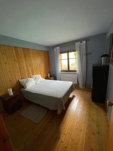a bedroom with a white bed and a window at Apartamento con espectacular terraza in Escarrilla