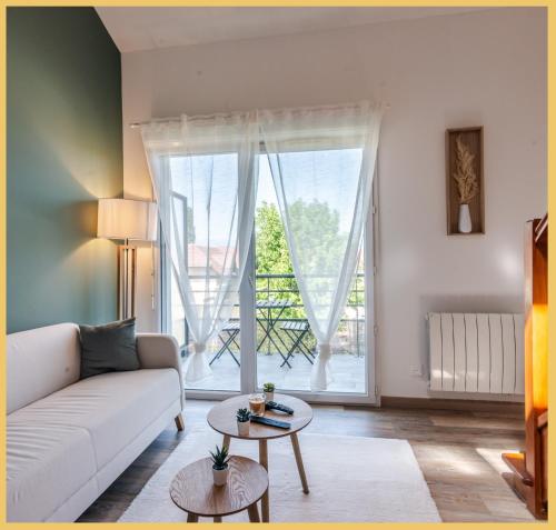 a living room with a white couch and a large window at Appartement T2 Moderne Neuf Collonge in Collonges-sous-Salève