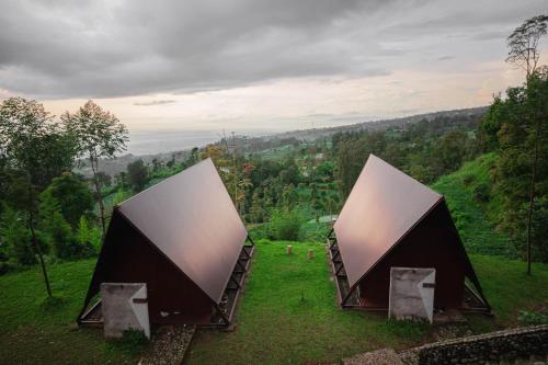 two tents in a field with a view of a valley at Kema Merbabu powered by Cocotel in Kembang
