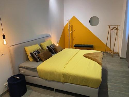 a bedroom with a bed with a yellow blanket at Les Quais de la Vesdre in Verviers