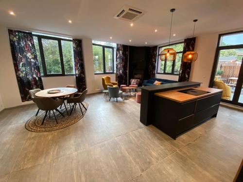 a living room with a kitchen and a table and chairs at Les Quais de la Vesdre in Verviers