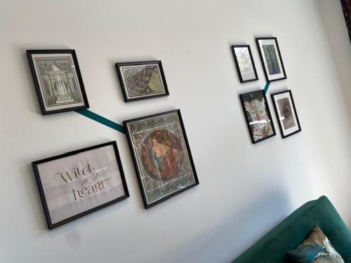 a group of framed pictures on a white wall at Les Quais de la Vesdre in Verviers