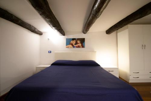 una camera con un letto e una coperta blu di Tom apartments a Napoli