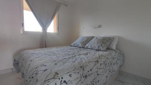 une chambre avec un lit avec une couette et une fenêtre dans l'établissement Victoria - Les Cles de l'Esterel, à Théoule-sur-Mer