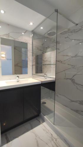 une salle de bain avec deux lavabos et une douche en verre dans l'établissement Victoria - Les Cles de l'Esterel, à Théoule-sur-Mer