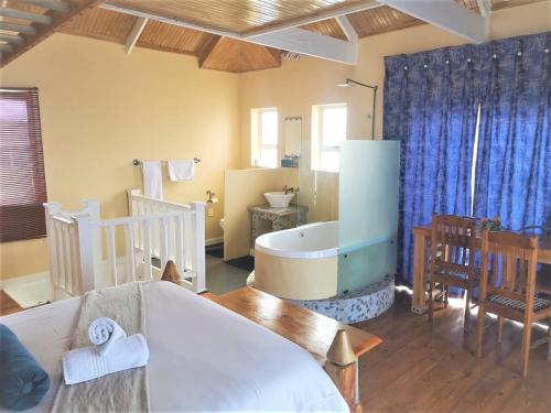 a living room with a bath tub and a bathroom at Point Village Guest House in Mossel Bay