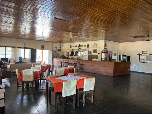 a restaurant with tables and chairs and a kitchen at Old West Walter Park in Santo Antônio do Pinhal