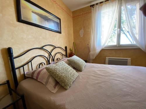 ein Schlafzimmer mit einem Bett mit zwei Kissen darauf in der Unterkunft Maison au calme piscine mer au coeur de la nature U Nuciolu in Talasani