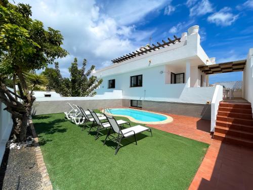 a villa with a swimming pool and lawn at Laguna Home by Best Holidays Fuerteventura in Corralejo