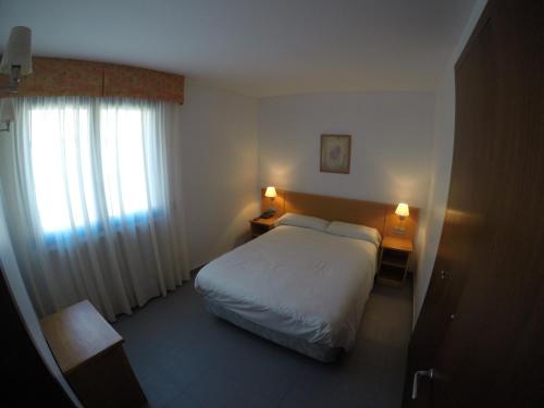 a hotel room with a bed and a window at Apartamentos Turísticos Roc Del Castell in Canillo