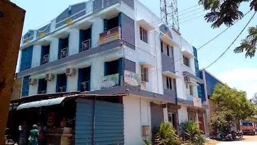 a large white building with blue shutters on it at OYO 81239 Shri Vinayaka Inn Rooms in Tiruchchirāppalli
