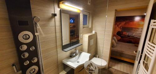 ein Badezimmer mit einem Waschbecken, einem WC und einem Spiegel in der Unterkunft Joy's apartman Molnári 