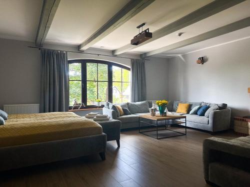 um quarto com uma cama, um sofá e uma mesa em EKWADOR Hotel Ośrodek Jeździecki em Barczewo