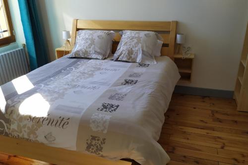 a bed with a white comforter and pillows at Chartreuse in Saint-Franc