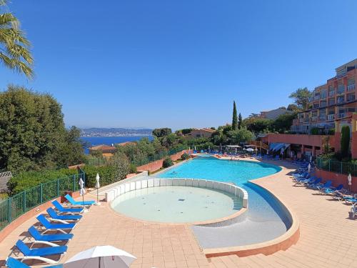 une grande piscine avec chaises longues et parasols dans l'établissement Victoria - Les Cles de l'Esterel, à Théoule-sur-Mer