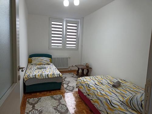 a bedroom with two beds and a window at Lux Apartment Sarajevo in Sarajevo