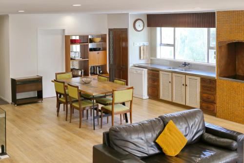 a kitchen and dining room with a table and a couch at Big family house Easy to Airport in Auckland