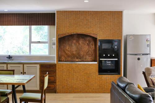 a kitchen with a brick wall with a refrigerator and a table at Big family house Easy to Airport in Auckland