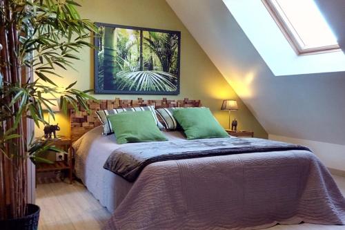 1 dormitorio con 1 cama grande con almohadas verdes en Ty Tiegezh Gîte TiDastum, en Créhen