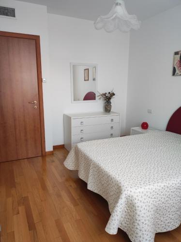 ein weißes Schlafzimmer mit einem Bett und Holzboden in der Unterkunft MARIA HOUSE for Agripolis in Legnaro