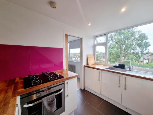 a kitchen with a stove top oven next to a sink at Bright top floor, 1 bed apartment in great location in London