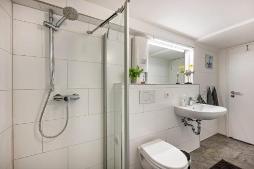ein Bad mit einer Dusche, einem WC und einem Waschbecken in der Unterkunft Meerlust Travemünde in Travemünde