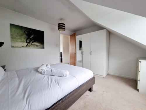 a bedroom with a large white bed in a attic at Bright top floor, 1 bed apartment in great location in London