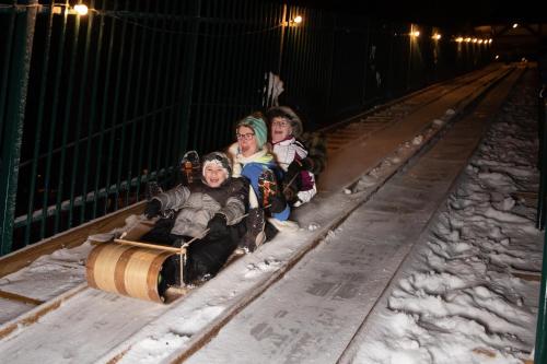 a group of people riding on a roller coaster in the snow at Lake Placid Inn Boutique Hotel in Lake Placid