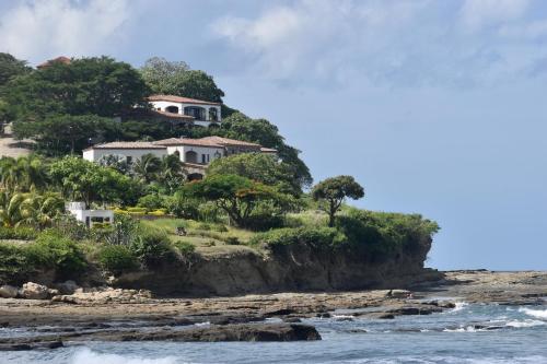 a house on a hill next to the ocean at Low Tide - Popoyo Aparts in Popoyo