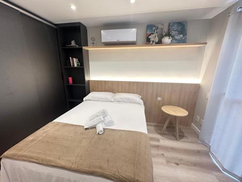a bedroom with a bed with a tv on the wall at Loft no Bairro Auxiliadora in Porto Alegre