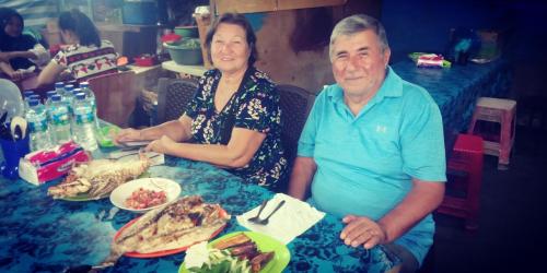 a man and a woman sitting at a table with food at Agus Family Homestay in Labuan Bajo