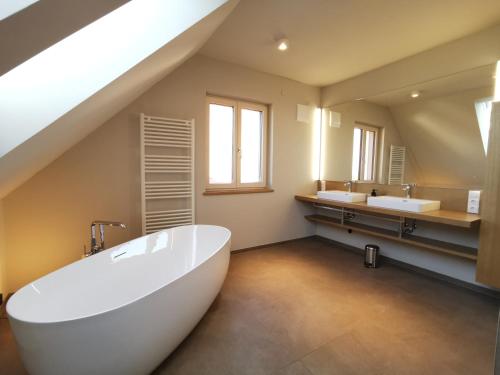 La salle de bains est pourvue d'une grande baignoire blanche et de 2 lavabos. dans l'établissement Traumhaftes Ferienhaus am Lateinberg - 8455 Eibiswald Südsteiermark, à Eibiswald