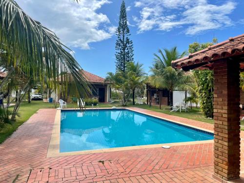 una piscina en un patio con una casa en Bangalô Amarelo en Prado