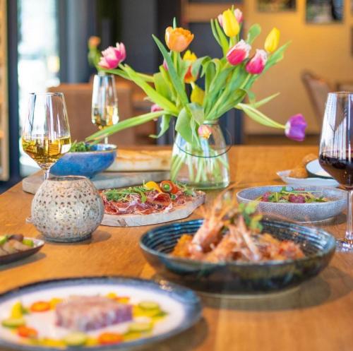 - une table avec des assiettes de nourriture et des verres de vin dans l'établissement Boutique Hotel Karel de Stoute, à Gorinchem