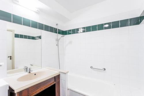 a white bathroom with a sink and a mirror at Résidence Les Belles Rives - maeva Home - Appartement 2 pièces 5 personnes - Confort MAE-2324 in Argentat
