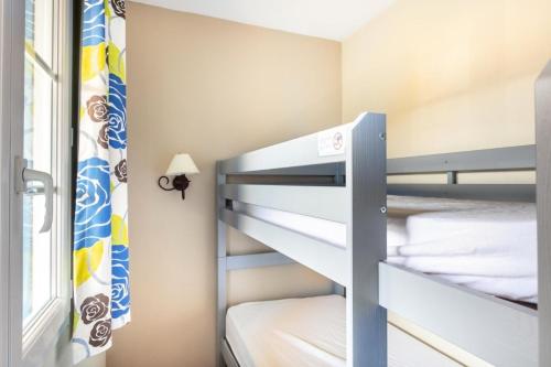 a small bedroom with bunk beds with a window at Résidence Les Belles Rives - maeva Home - Appartement 2 pièces 5 personnes - Confort MAE-2324 in Argentat