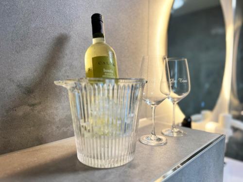 a bottle of wine in a blender next to two wine glasses at Hotel Da Toni in Neuenkirchen