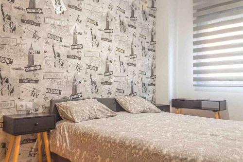 1 dormitorio con 1 cama y una pared cubierta de periódicos en Apartment Central House, en Castellón de la Plana