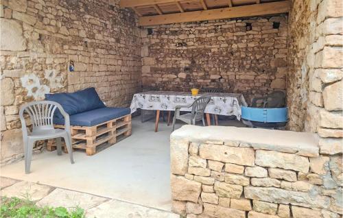 a patio with a table and chairs and a brick wall at Cozy Home In Saint-vincent-la-chtr With Wifi in Saint-Vincent-la-Châtre
