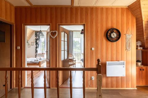 a room with wooden walls and a clock on the wall at ZAKOHOME Dom Banysiówka in Dzianisz