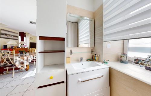 La salle de bains blanche est pourvue d'un lavabo et d'une fenêtre. dans l'établissement 2 Bedroom Nice Home In Dol-de-bretagne, à Dol-de-Bretagne