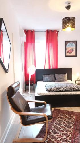 a bedroom with a bed and a chair in it at Chambres en appartements partagés in Liège