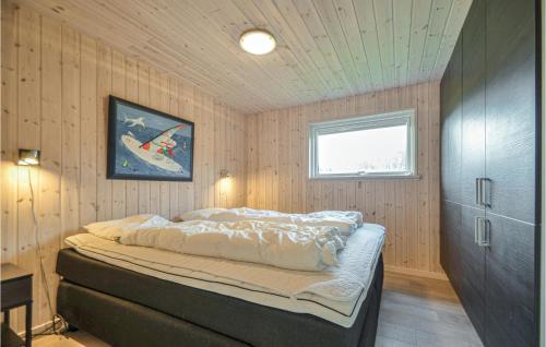 KnebelにあるStunning Home In Ebeltoft With 3 Bedrooms, Sauna And Wifiの木製の壁のベッドルーム1室(ベッド1台付)