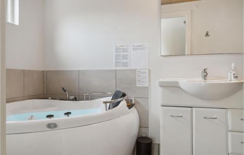 een witte badkamer met een bad en een wastafel bij Nice Home In Vggerlse With Wifi in Bøtø By